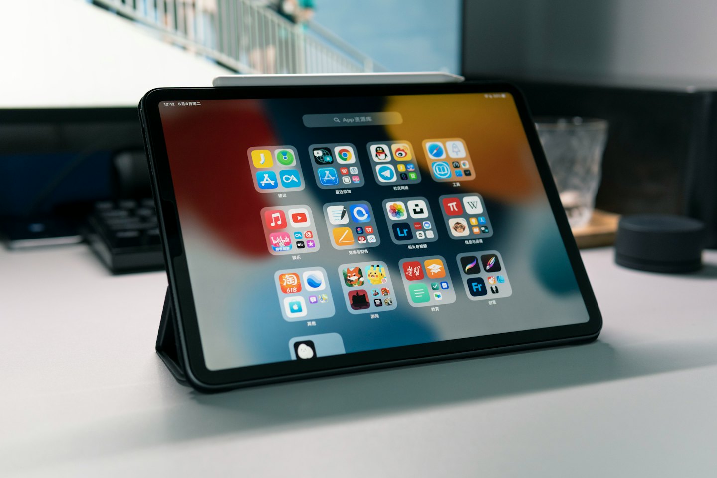 Tablet mit bunten App-Symbolen auf einem weißen Schreibtisch.